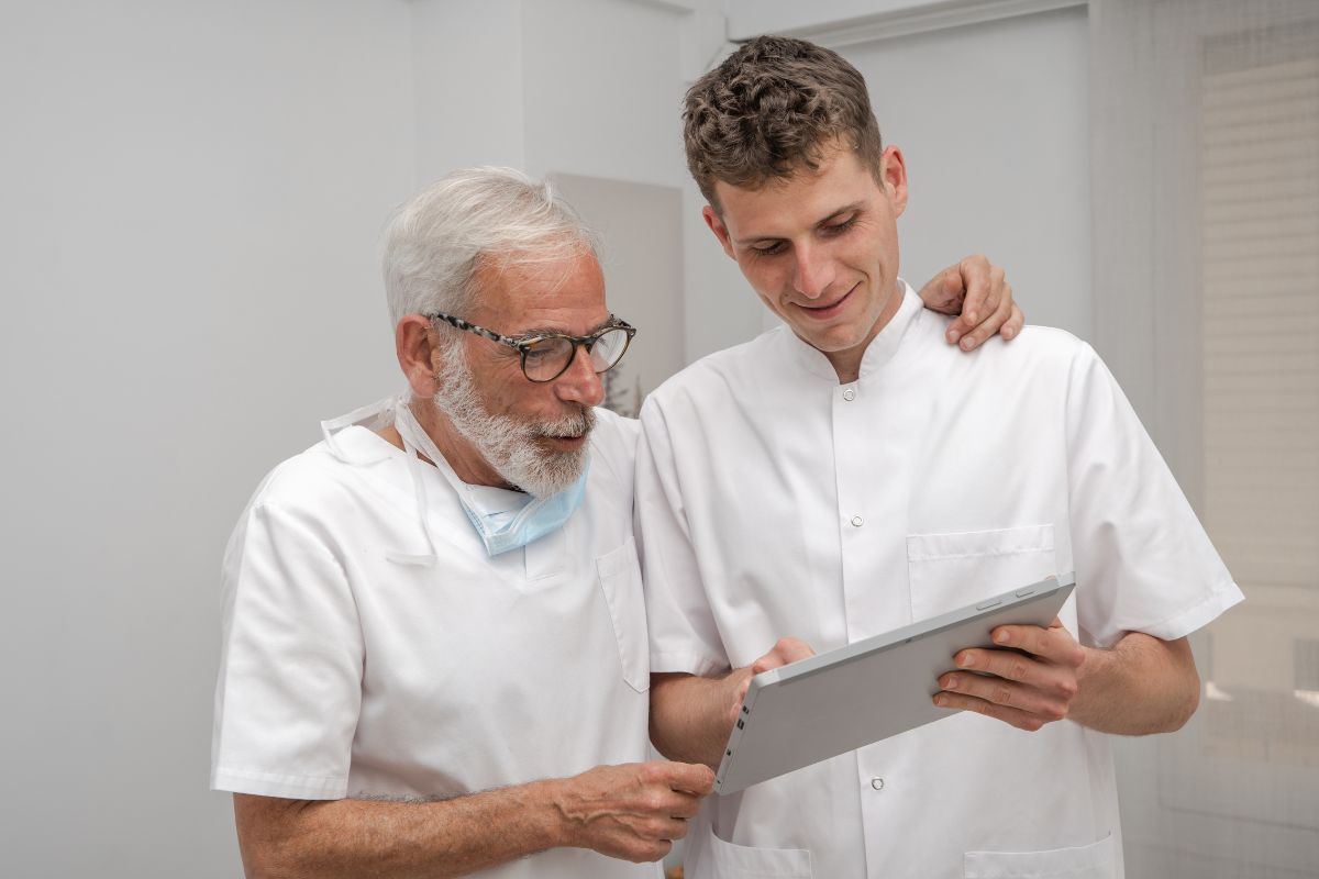 Medici padre e figlio che argomentano osservando un tablet